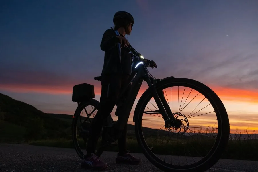 Cyklist med elcykel i solnedgången utanför Örnsköldsvik