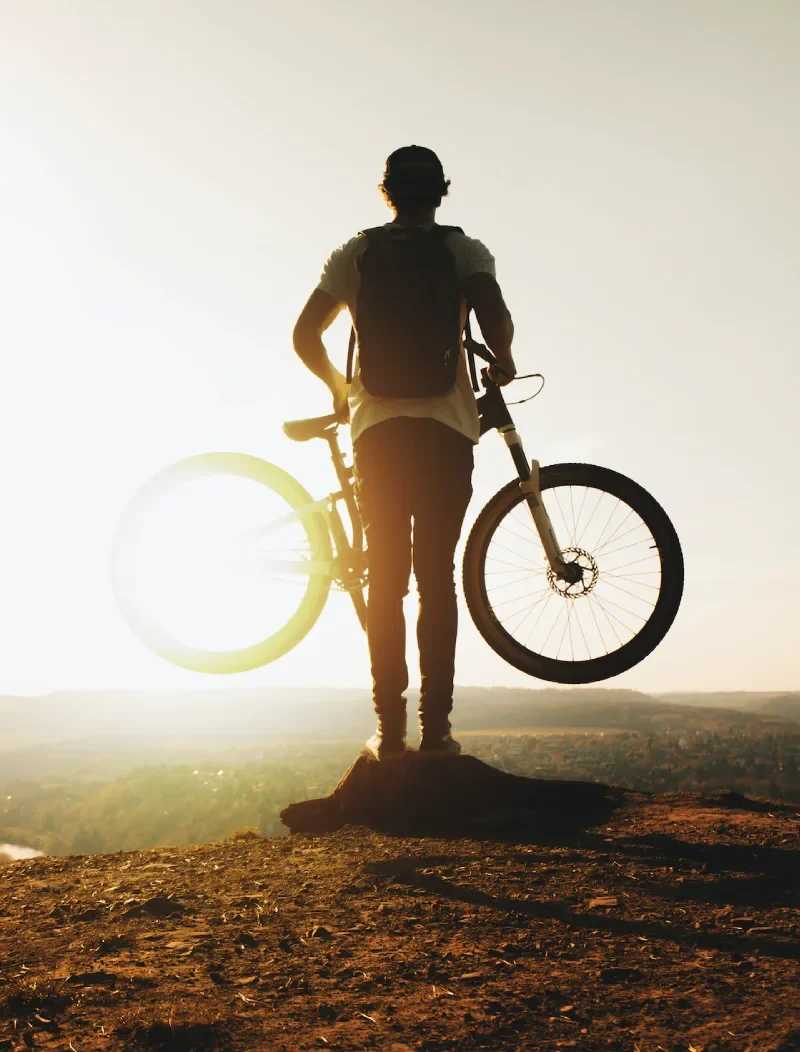 Cyklist med mountainbike på ett berg i solnedgången utanför Örnsköldsvik